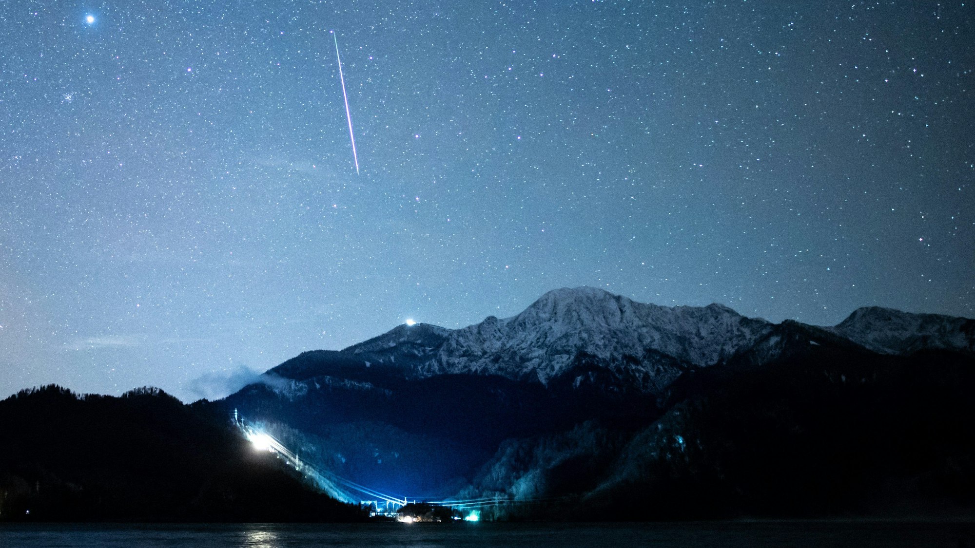 Eine Sternschnuppe ist während der Geminiden über dem Kochelsee in Bayern zu sehen.