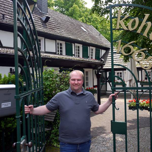 Magnus Thelen steht im Tor der Gaststätte Kohberg und lächelt in die Kamera.