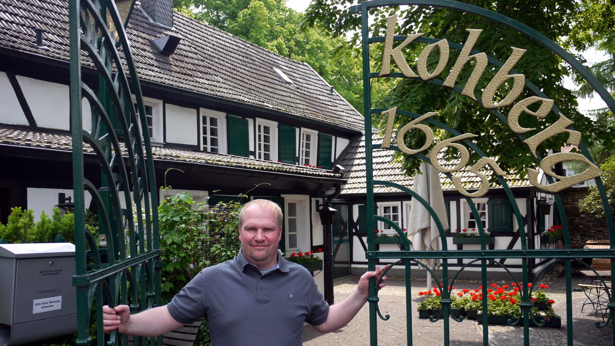 Magnus Thelen steht im Tor der Gaststätte Kohberg und lächelt in die Kamera.