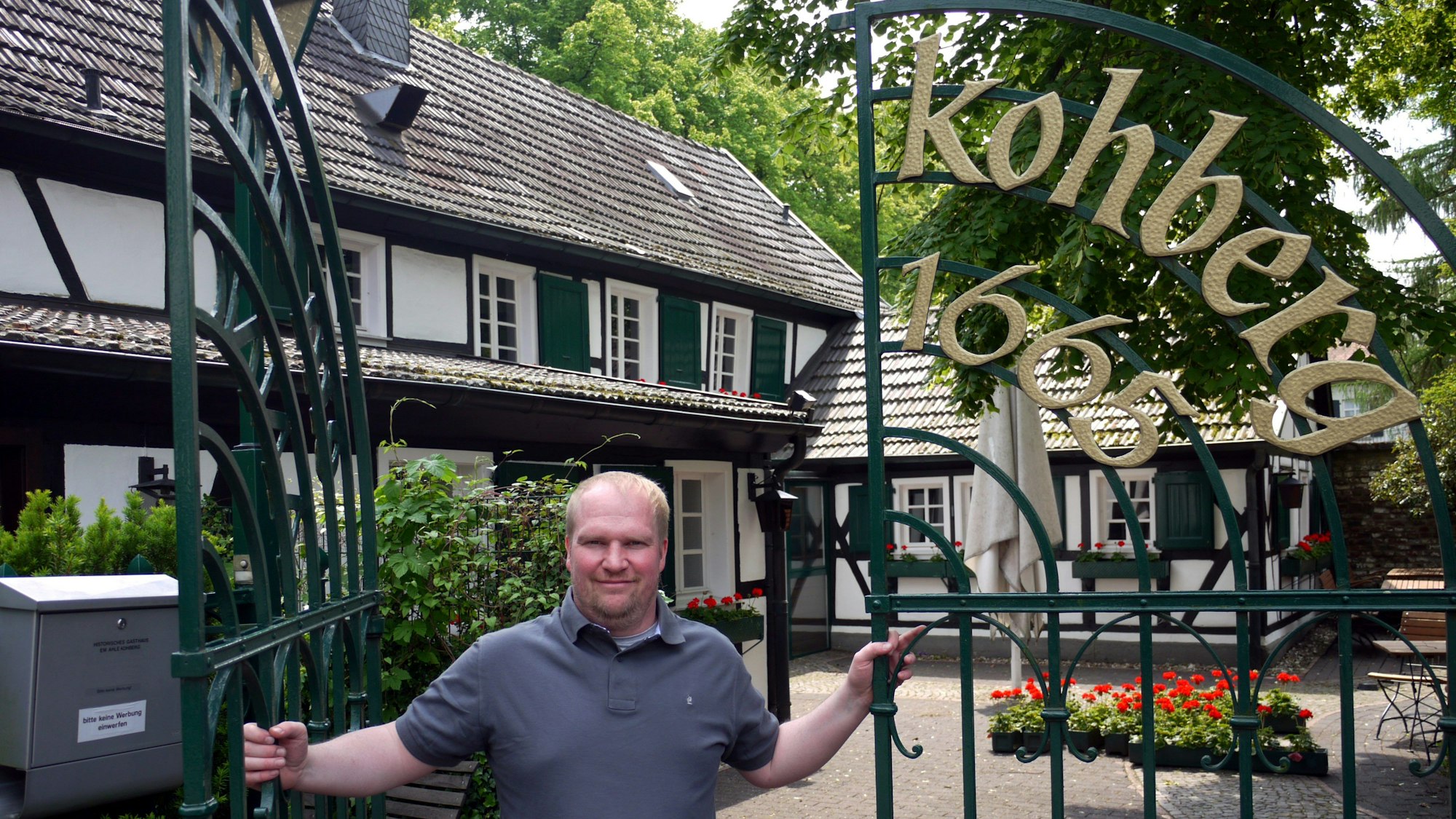Magnus Thelen steht im Tor der Gaststätte Kohberg und lächelt in die Kamera.