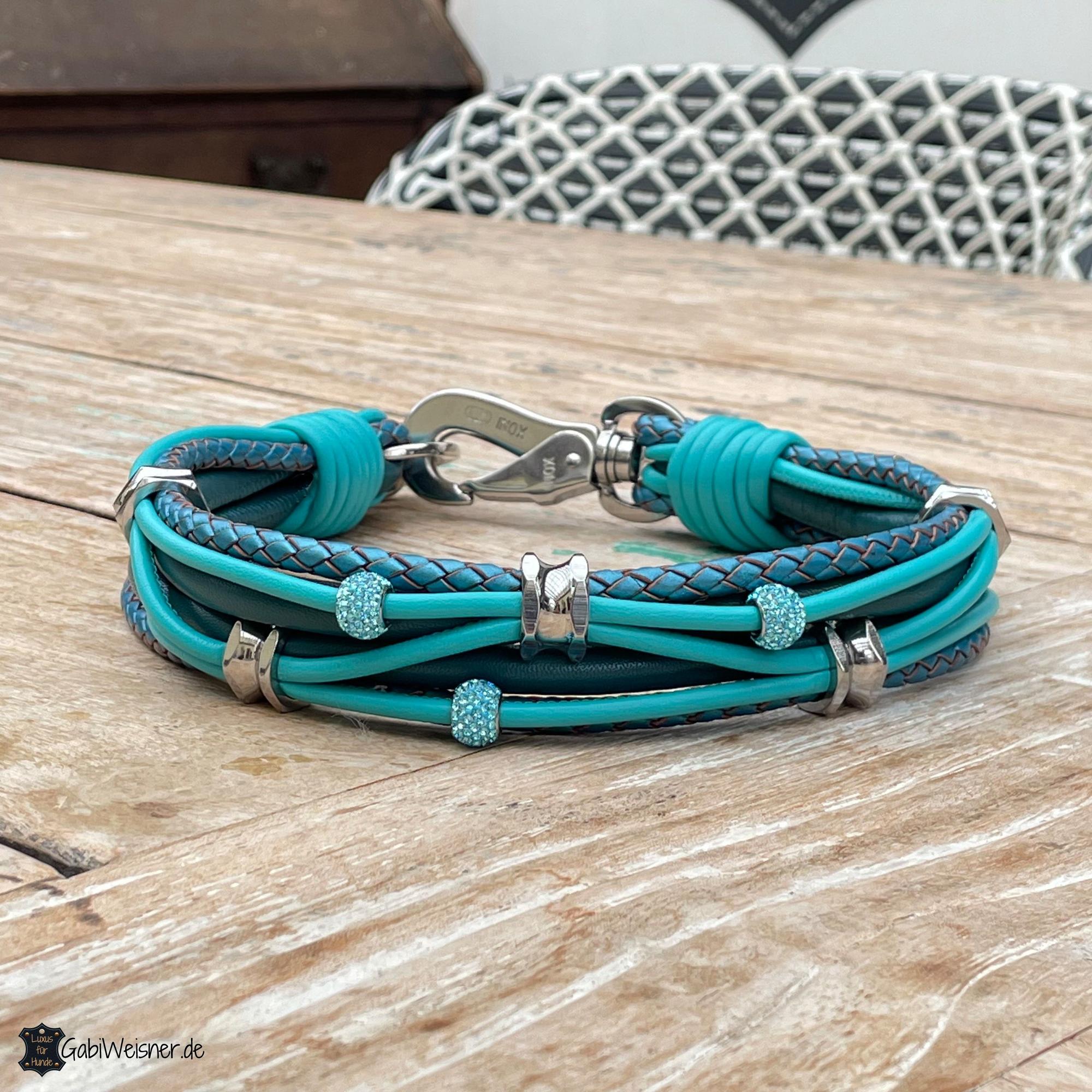 Ein blaues Hundehalsband mit Glitzeranhängern und ausgefallenem Verschluss.