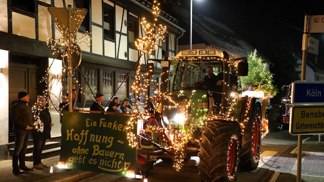 Ein geschmückter Traktor fährt durch die Bensberger Straße in Overath-Heiligenhaus.