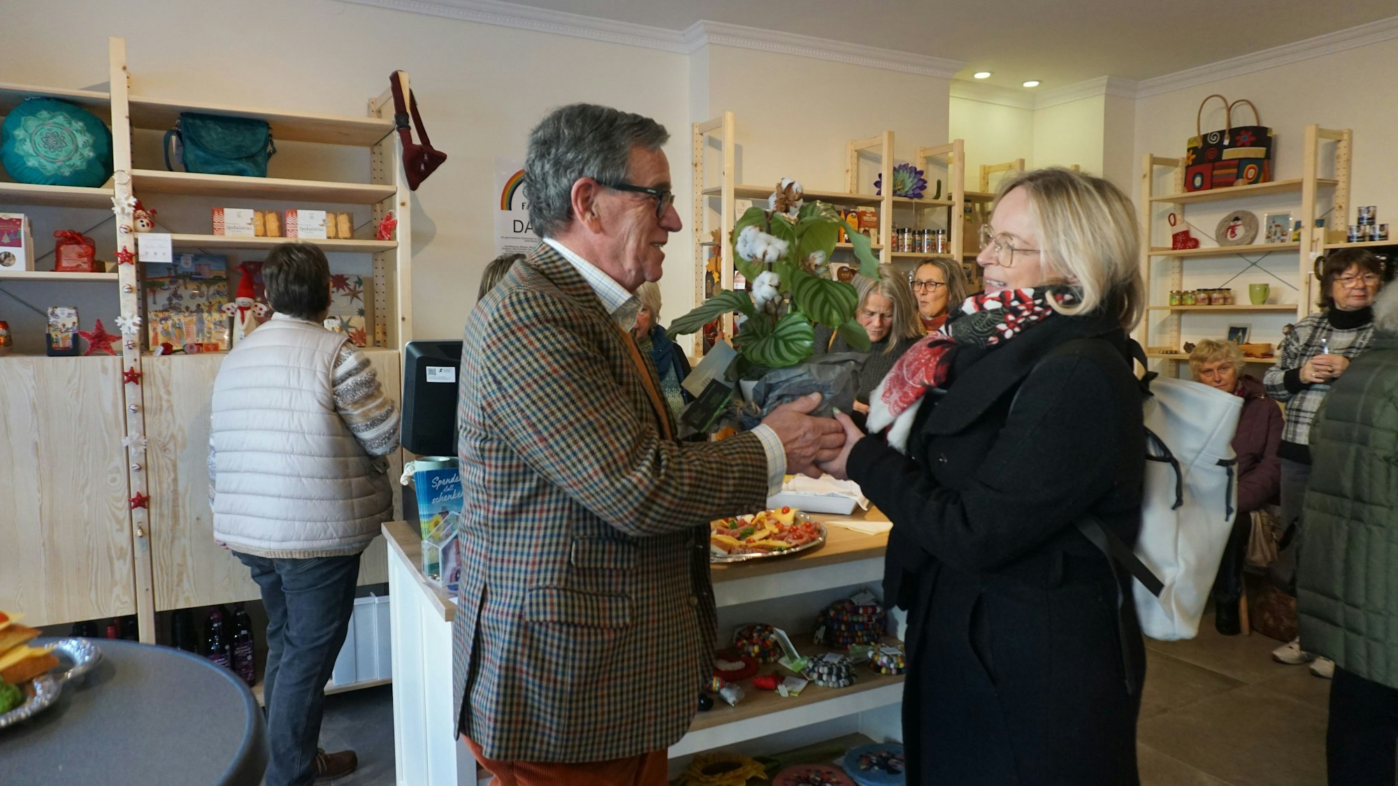 Bad Münstereifels Bürgermeisterin Sabine Preiser-Marian überreicht dem Vorsitzenden Heinz-Wolfgang Zimmermann Blumen zur Eröffnung des Fairen Ecks.