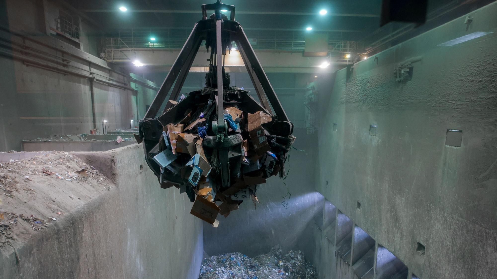 Ein Müllgreifer hebt die Kartons mit den Schmuggelzigaretten in den Müllofen der Verbrennungsanlage in Eschweiler.