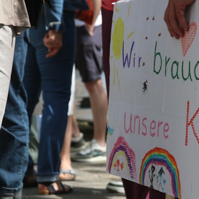 Eltern und Kinder der Evangelischen Kita in Zollstock demonstrieren mit Schildern gegen die geplante Schließung der Einrichtung.