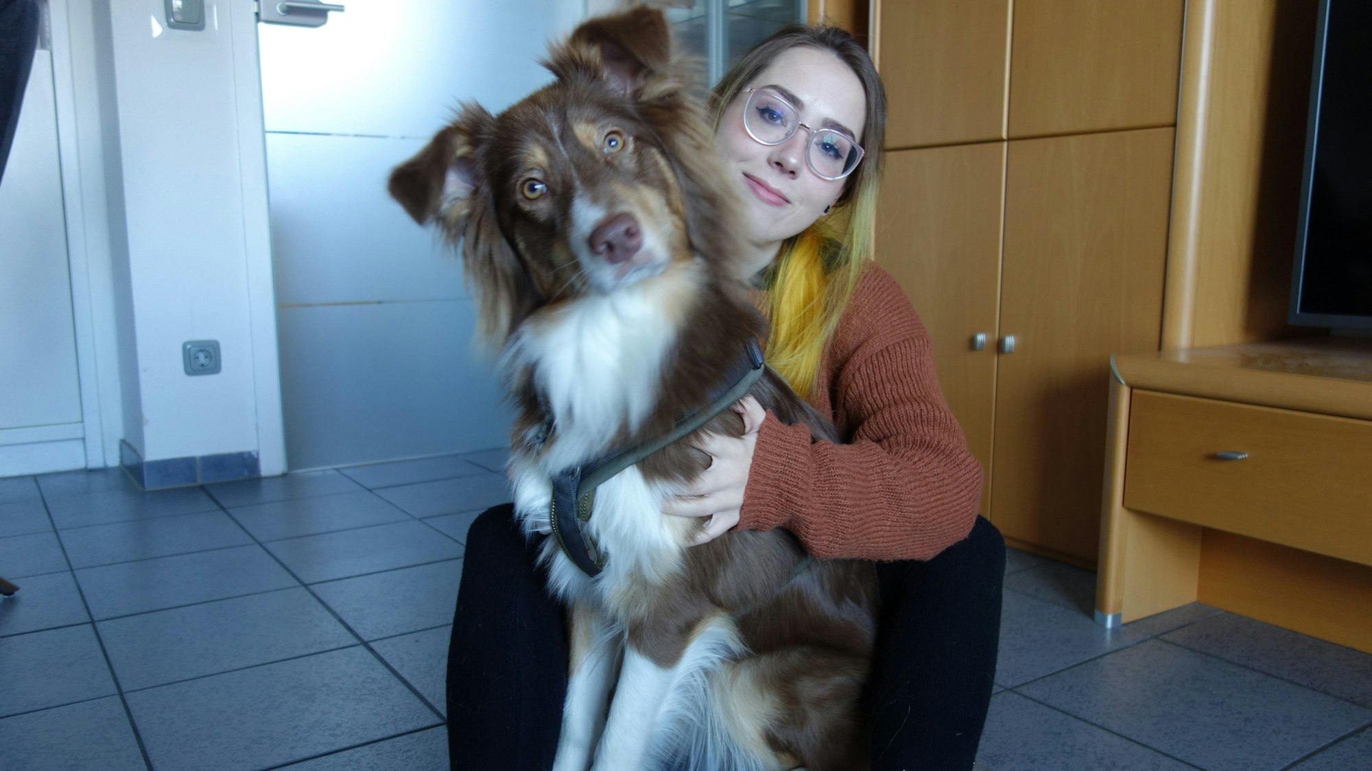 Die 29-jährige Leverkusenerin Sissy Fischer mit ihrer Australian Shepherd Assistenzhündin im Wohnzimmer.