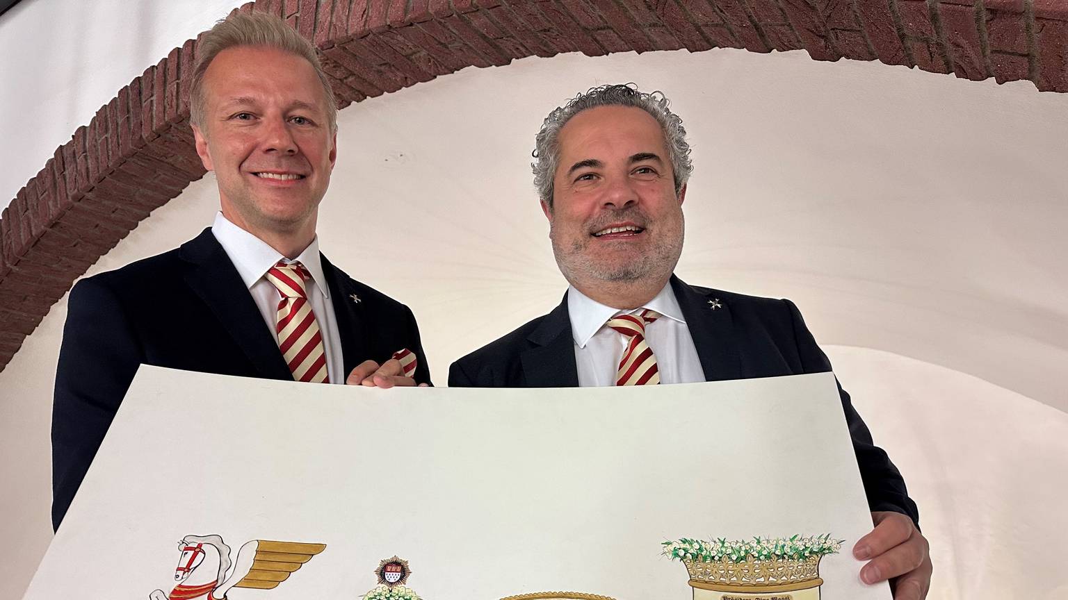 Marcus Gottschalk und Dino Massi zeigen einen Entwurf für den neuen Präsidentenwagen der Prinzen-Garde für den Rosenmontagszug 2023.