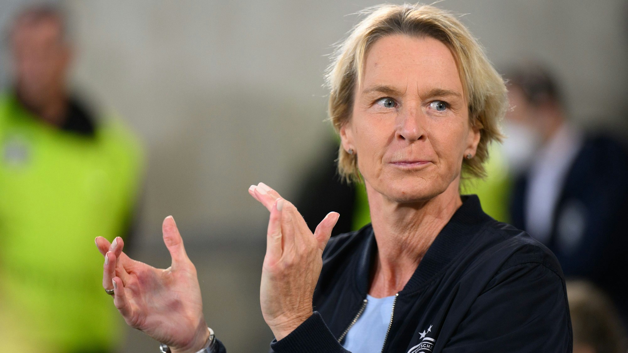 Deutschlands Frauen-Bundestrainerin Martina Voss-Tecklenburg steht am Spielfeldrand und klatscht in die Hände.