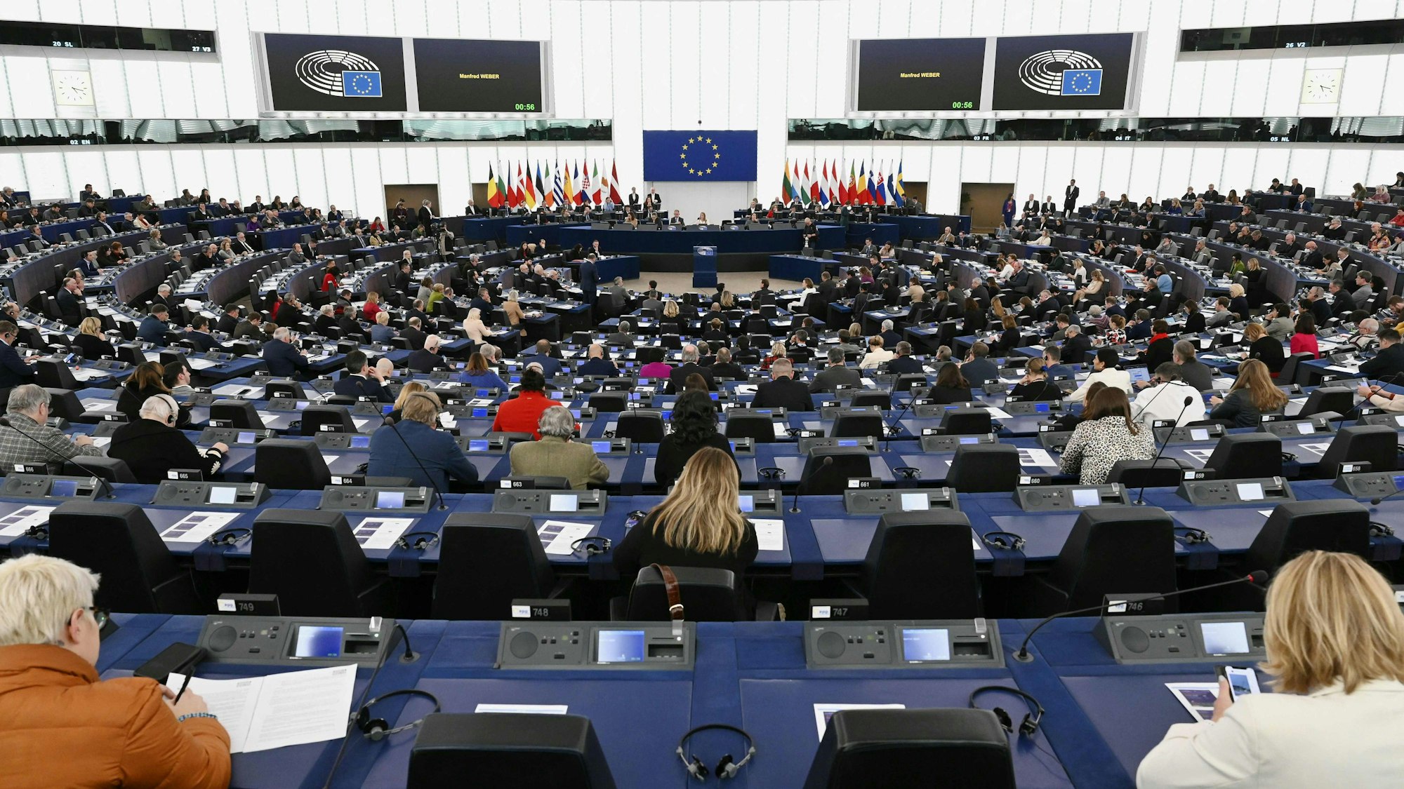 Mitglieder des Europäischen Parlaments nehmen an der Eröffnungssitzung des Europäischen Parlaments in Straßburg teil. Sie sitzen in einem großen, runden Saal. Vorne ist die EU-Flagge angebracht.