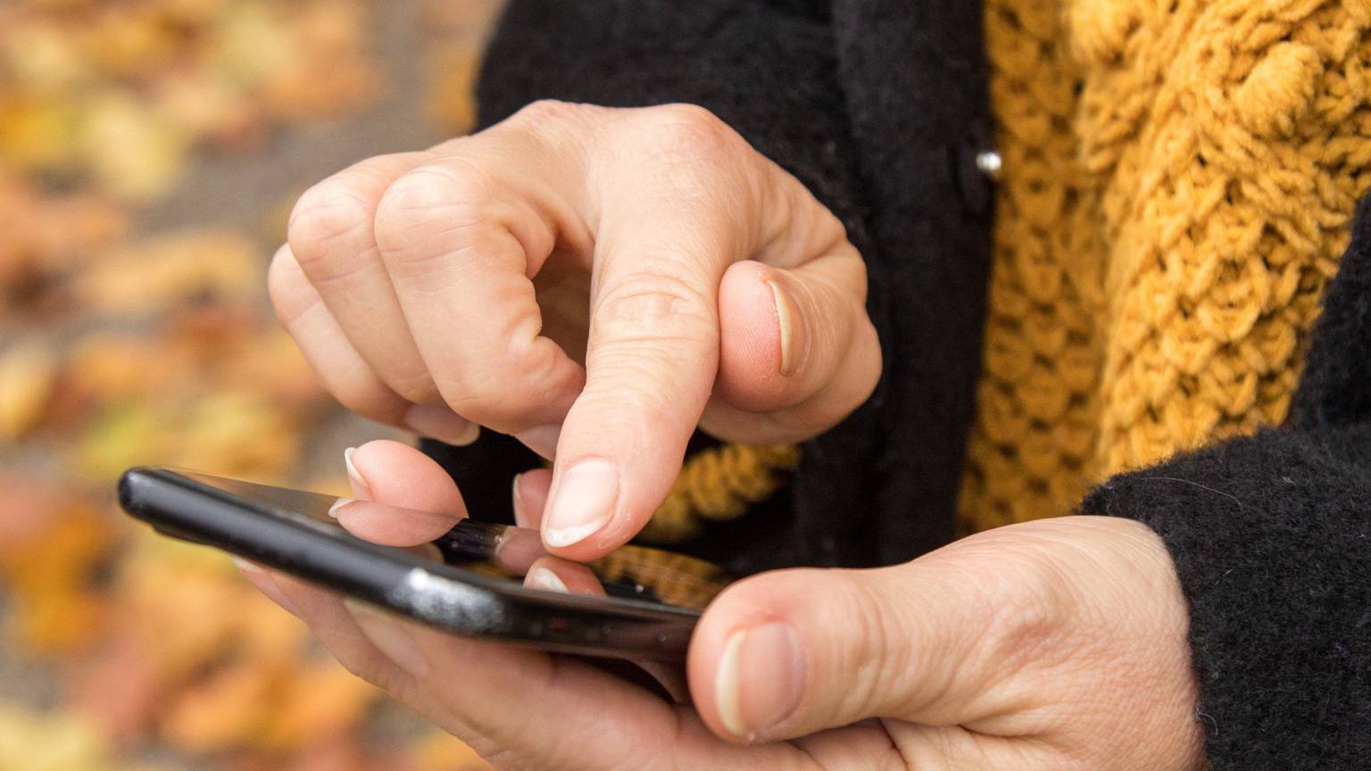 Das Foto zeigt Frauenhände, die ein Handy bedienen. Auch über das mobile Telefon lassen sich E-Mails abrufen.