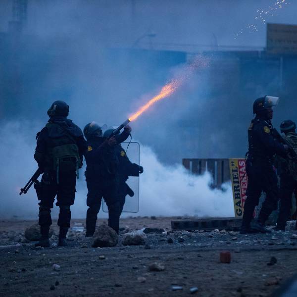 Peru, Arequipa: Ein Polizist feuert Tränengas in Richtung von Demonmstranten während eines Protests.
