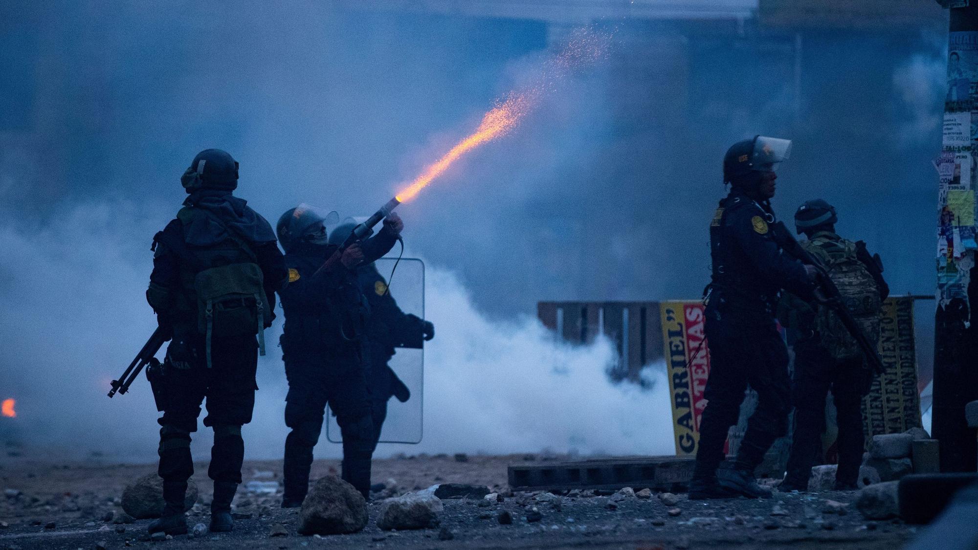 Peru, Arequipa: Ein Polizist feuert Tränengas in Richtung von Demonmstranten während eines Protests.