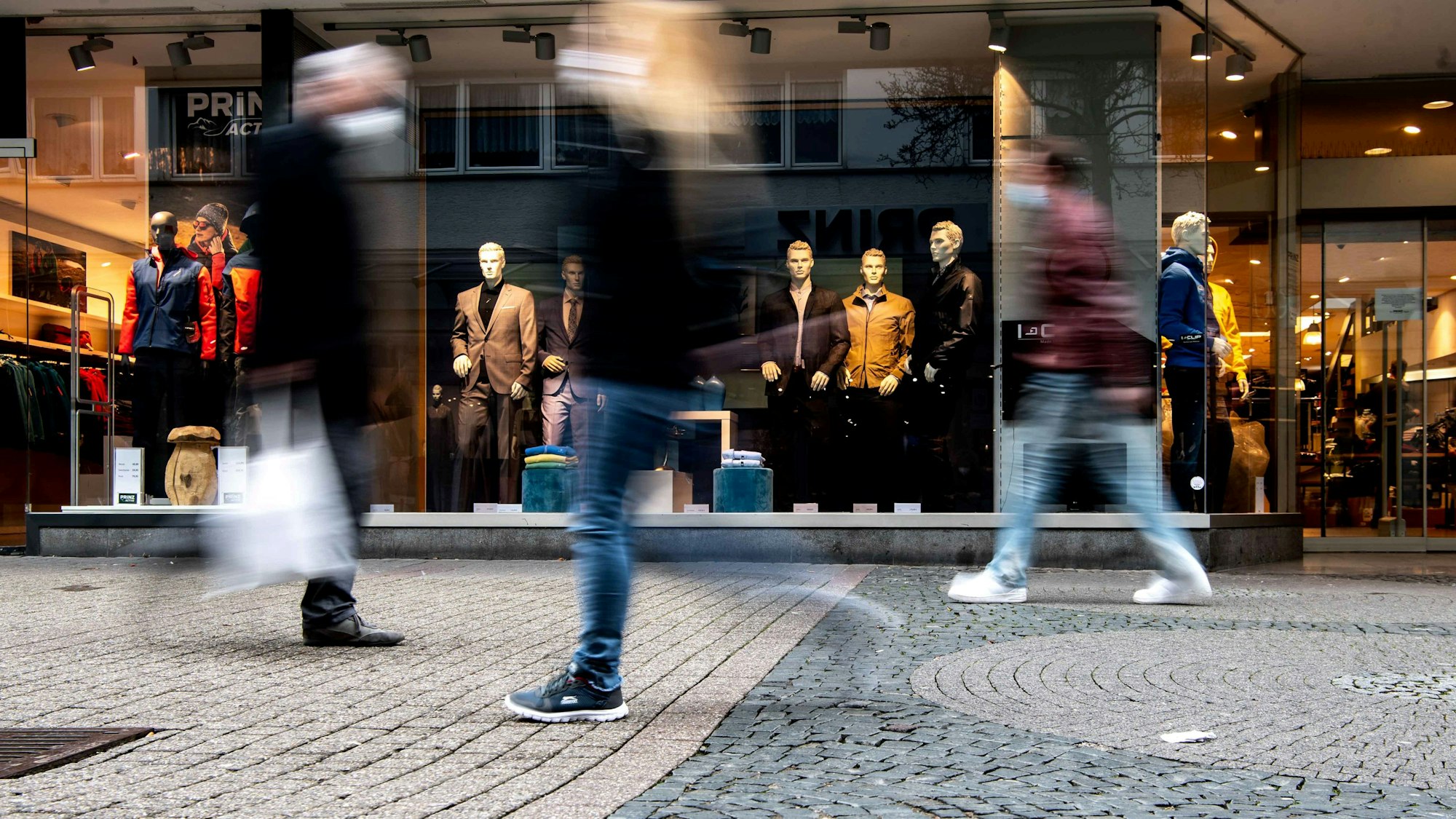 Das Bild zeigt die Fußgängerzone von Euskirchen. Drei Passanten schlendern durch die Innenstadt.