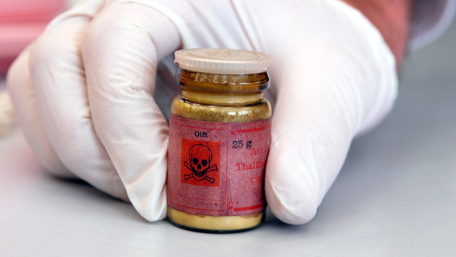 Eine Flasche mit Rattengift aus Thallium, markiert mit einem Totenkopfsymbol auf dem roten Etikett.