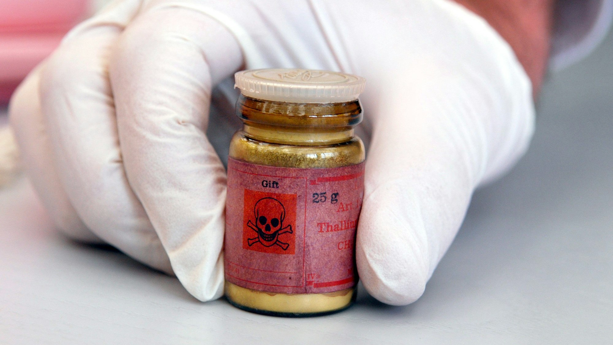 Eine Flasche mit Rattengift aus Thallium, markiert mit einem Totenkopfsymbol auf dem roten Etikett.