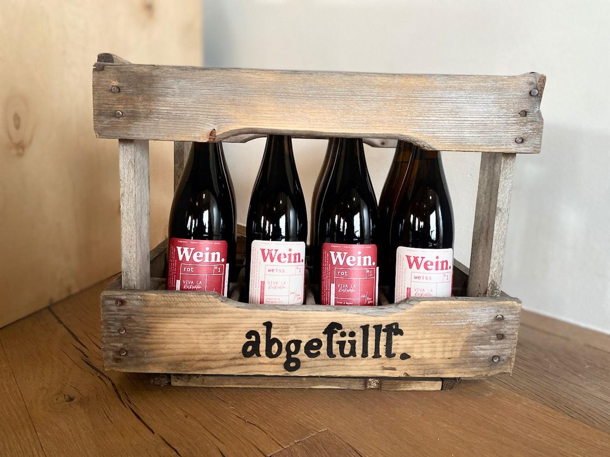 Eine Holzkiste gefüllt mit Weinflaschen des Start-ups „abgefüllt".