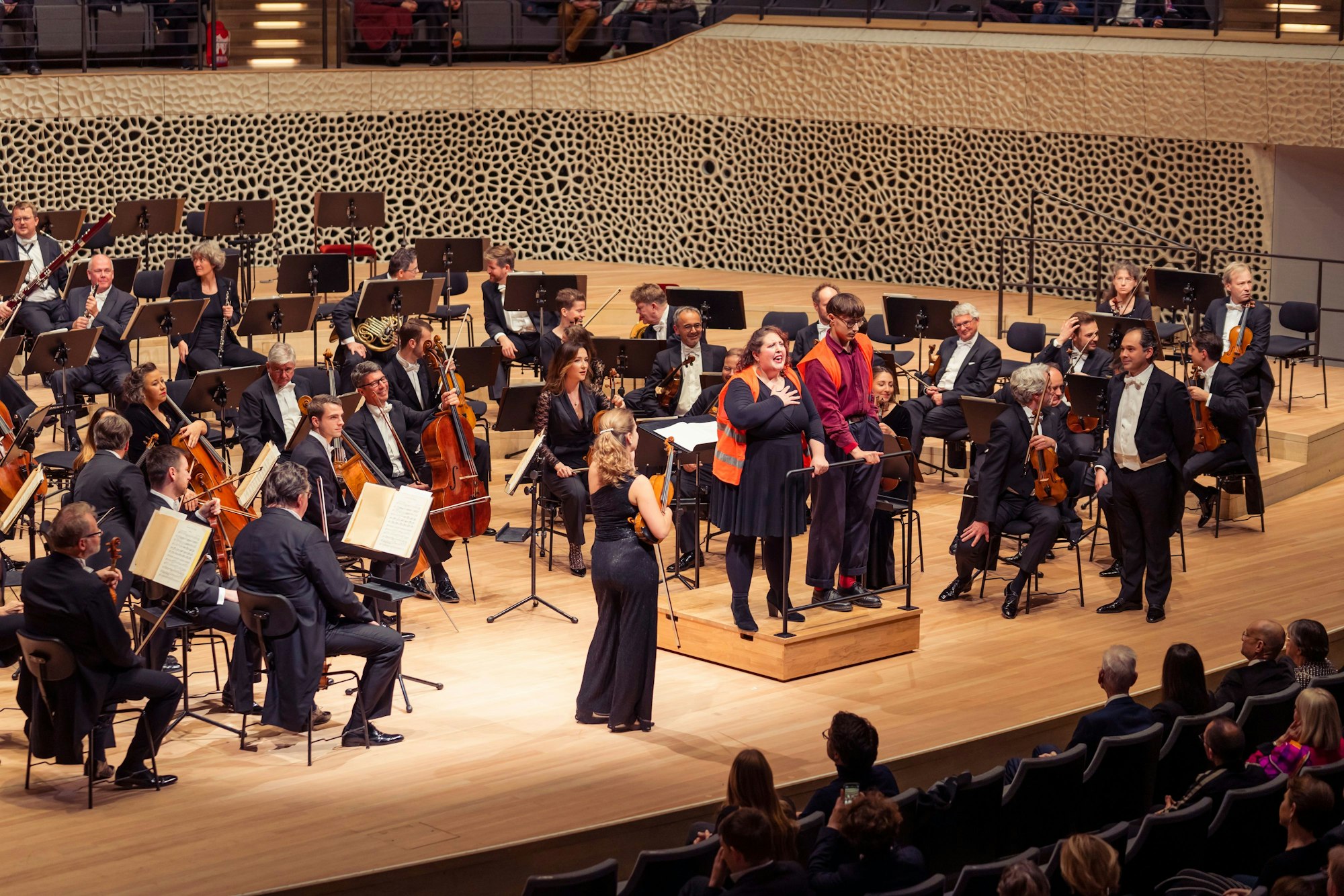 Zwei Aktivisten stehen auf der Bühne der Elbphilharmonie. Kurz vor Beginn eines Konzerts in der Elbphilharmonie haben Klimaaktivisten der «Letzten Generation» sich an einem Dirigentenpult festgeklebt.