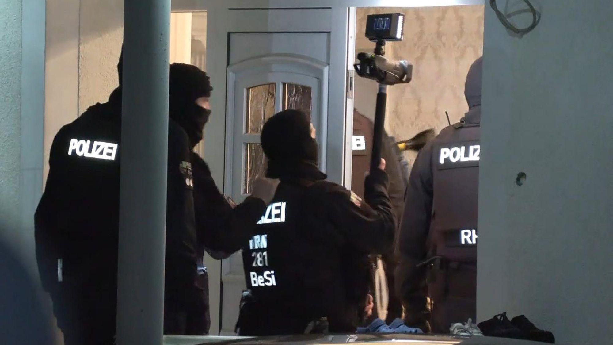 Solingen: Polizisten dringen im Rahmen einer groß angelegten Razzia in ein Haus ein.