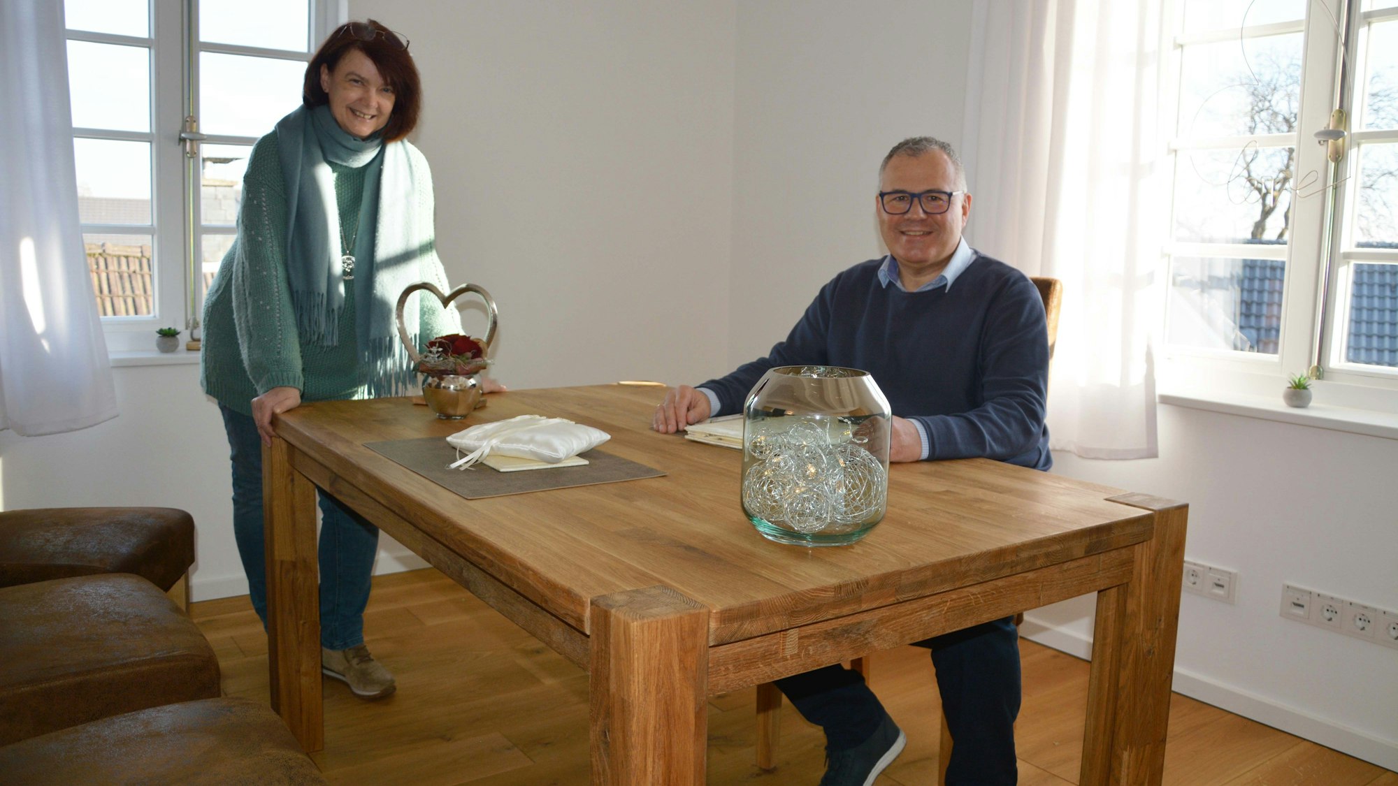 Brigitte Gutendorf, Amtsleiterin des Bürgerbüros und des Standesamts, und Bürgermeister Frank Steffes am Holztisch im hellen neuen Trauzimmer.
