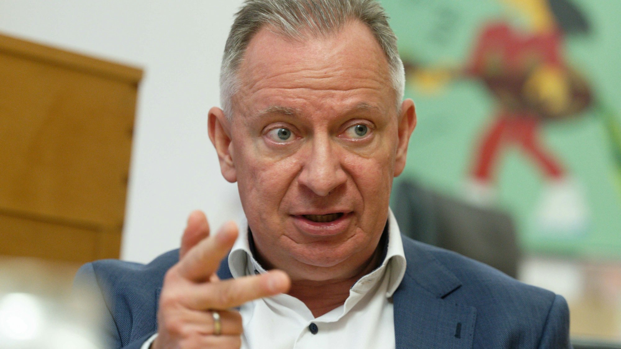 Stephan Pusch, Landrat im Kreis Heinsberg (CDU), spricht in seinem Büro und gestikuliert dabei mit seiner Hand. Er trägt einen Anzug.