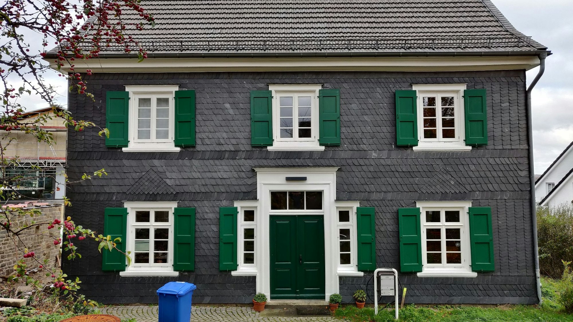 Der Eingang zum mit Schiefer verkleideten Fachwerkhaus des alten evangelischen Pastorats.