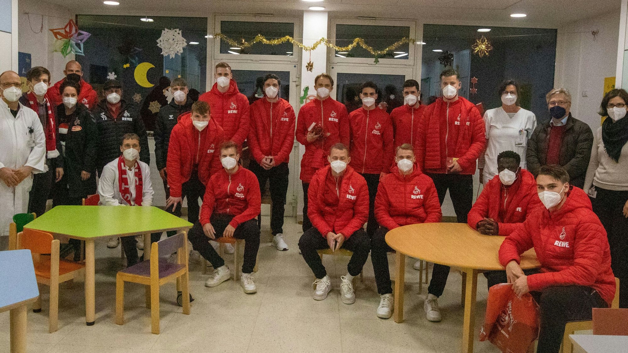 Die Spieler des 1. FC Köln posieren für ein Gruppenfoto mit dem Krankenhauspersonal.