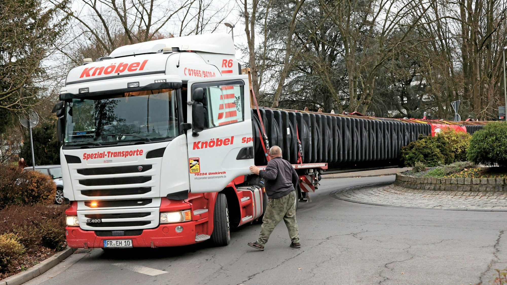 Lkw-Fahrer Jan Garwecki steht vor der geöffneten Fahrertüre des Lastzuges, der im Kreisel feststeckt.