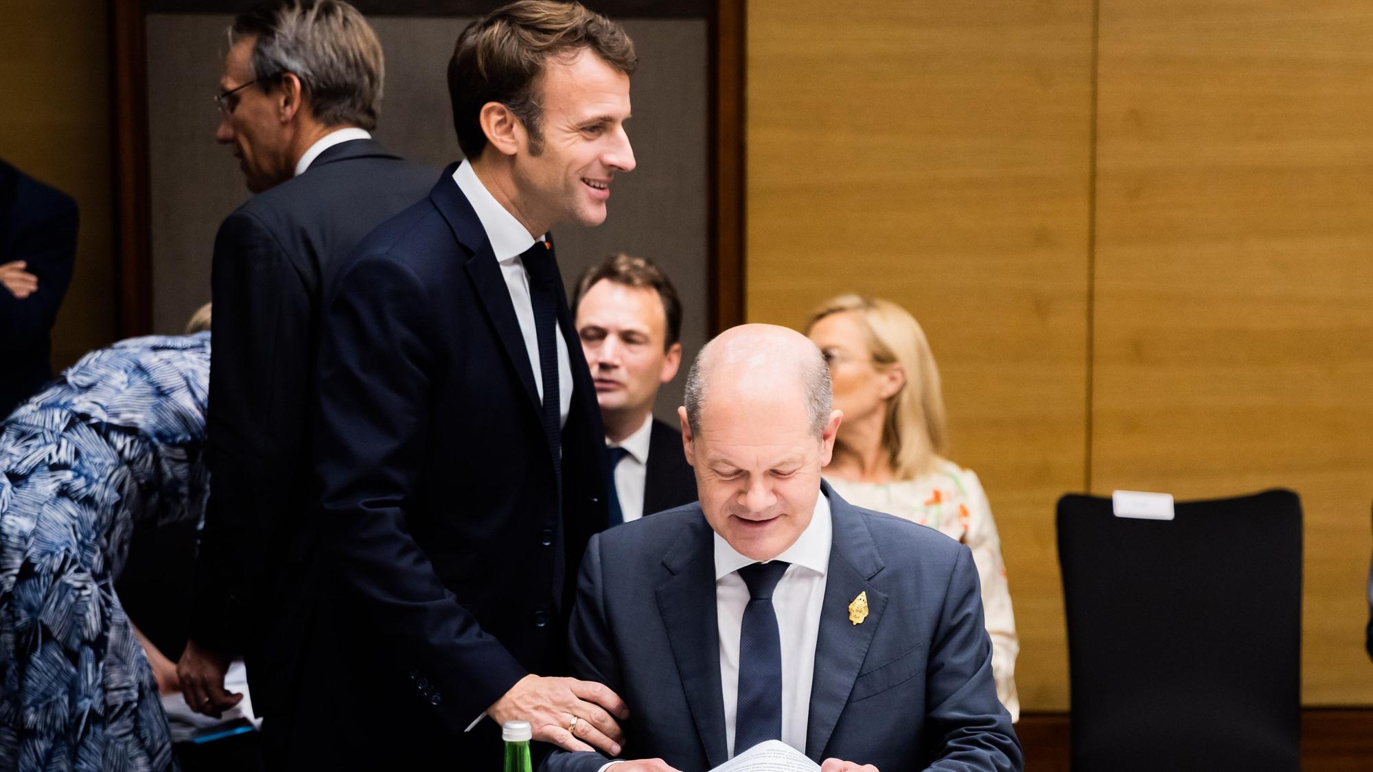 Emmanuel Macron (l), Präsident von Frankreich, begrüßt Bundeskanzler Olaf Scholz (SPD) beim G20-Gipfel bei einem sogenannten Side Event.