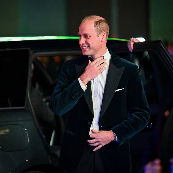 Prinz William mit Fliege und Anzug. Er grinst und steigt aus einem Auto.