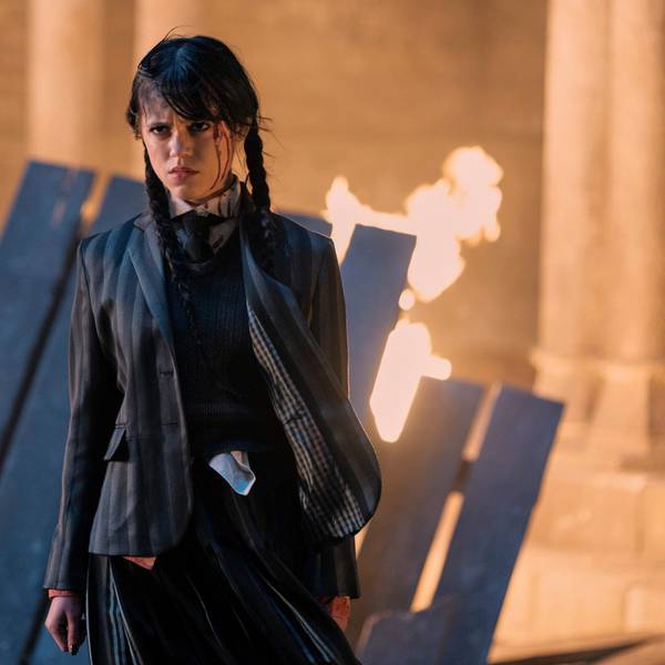 Jenna Ortega steht in einer Serienszene vor einem brennenden Bretterhaufen.