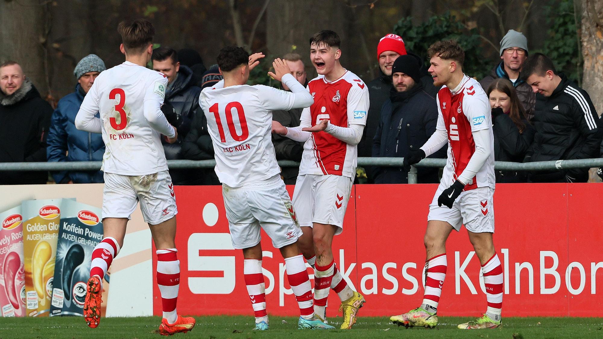 Vier Fußballspieler jubeln über ein Tor.