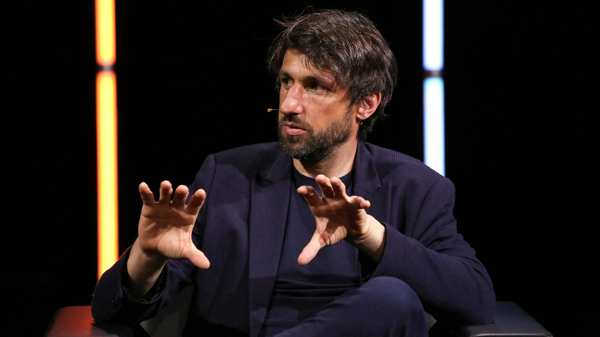 Thomas Broich bei einem Auftritt auf der Kölner Lit Cologne, der ehemalige Fußballprofi und heutige TV-Experte trägt Anzug und diskutiert gestenreich,