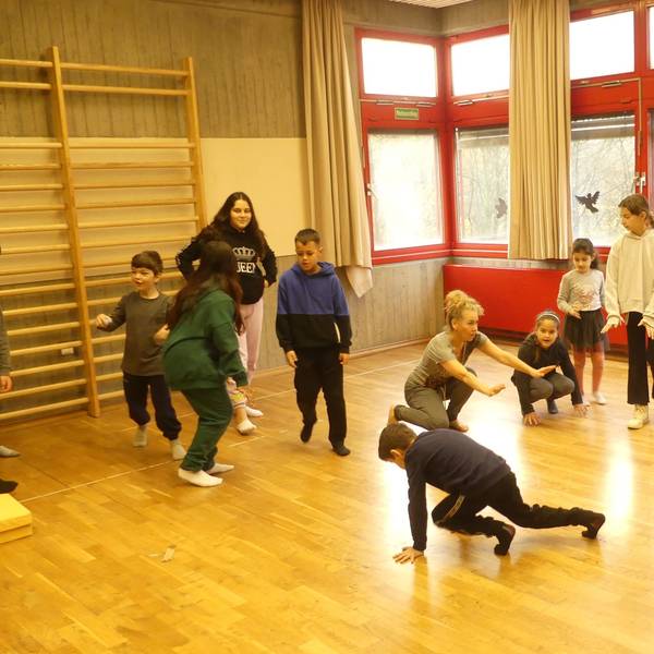 Grundschüler bewegen sich in einer Turnhalle wie Tiere der Arktis.
