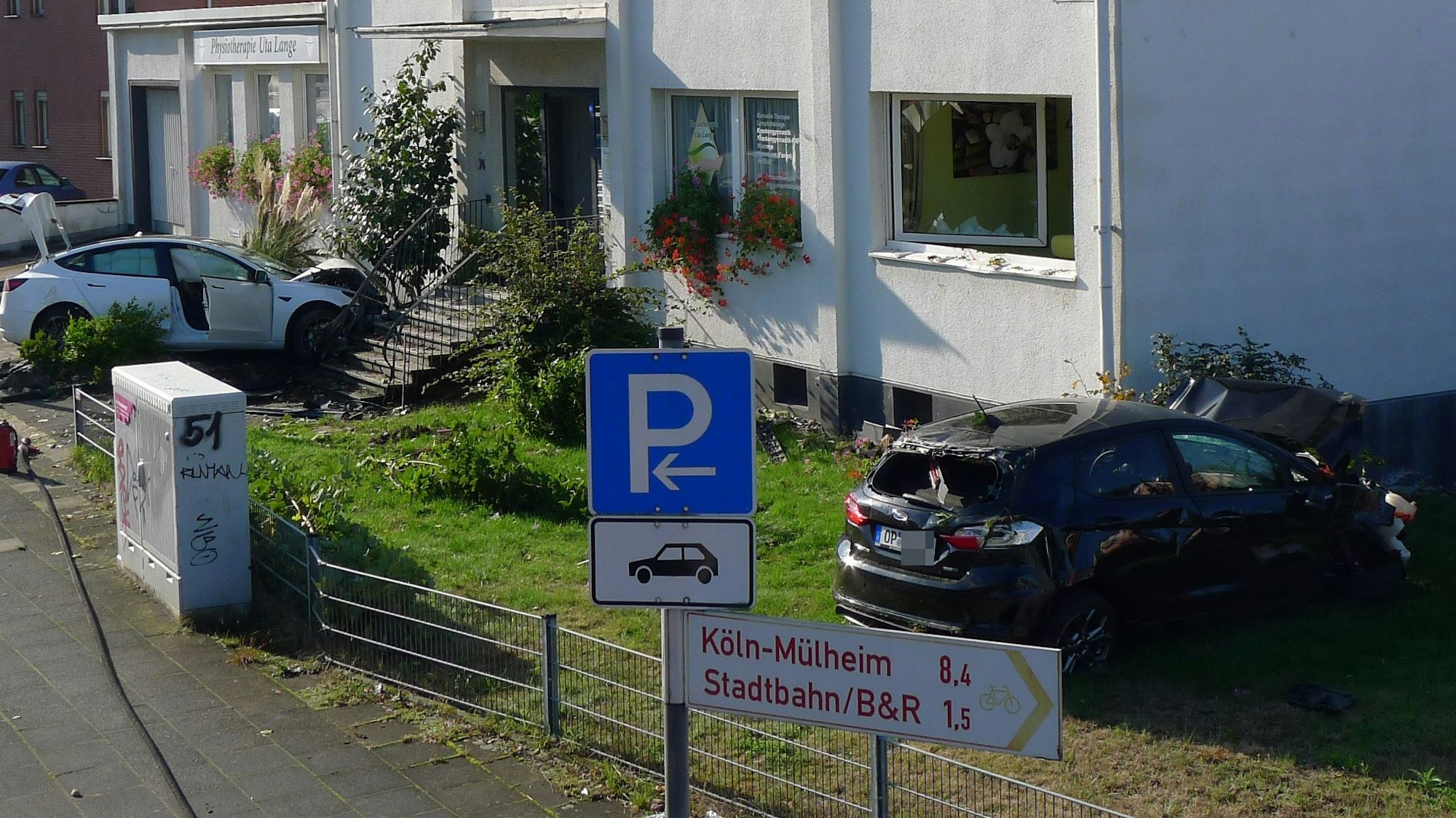 Unfall Bensberger Straße Tesla, Herzinfarkt des Fahrers. Geparkter Ford fliegt in ein Fenster. Foto: Ralf Krieger