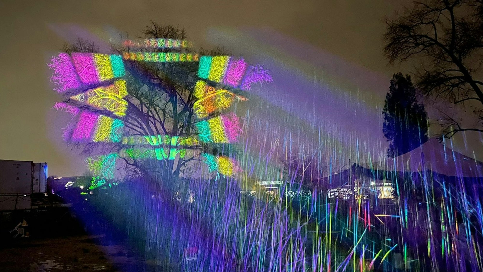 Ein bunt beleuchteter Baum auf dem Gelände des Südlichter-Festivals an der Südbrücke in Köln Poll.