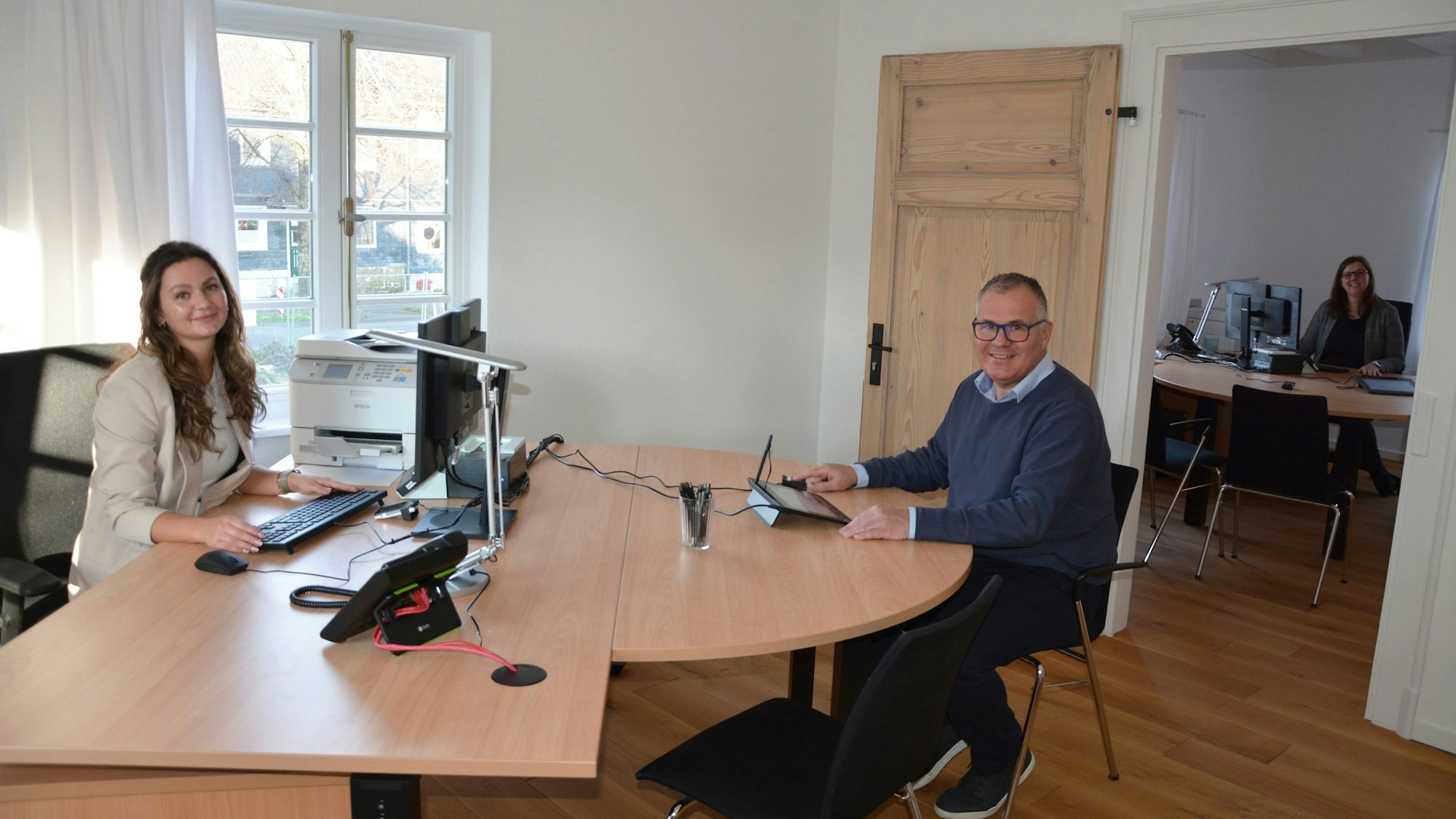 Stephanie Lochelfeldt vom Bürgerbüro und Bürgermeister Frank Steffes sitzen am Schreibtisch, im Hintergrund Standesbeamtin sitzt Britta Peddenbruch im zweiten Büroraum.