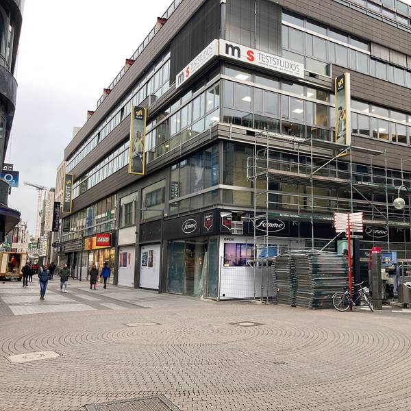 Das Bild zeigt ein Geschäftshaus auf der Hohe Straße, Arbeiter errichten gerade ein Baugerüst.