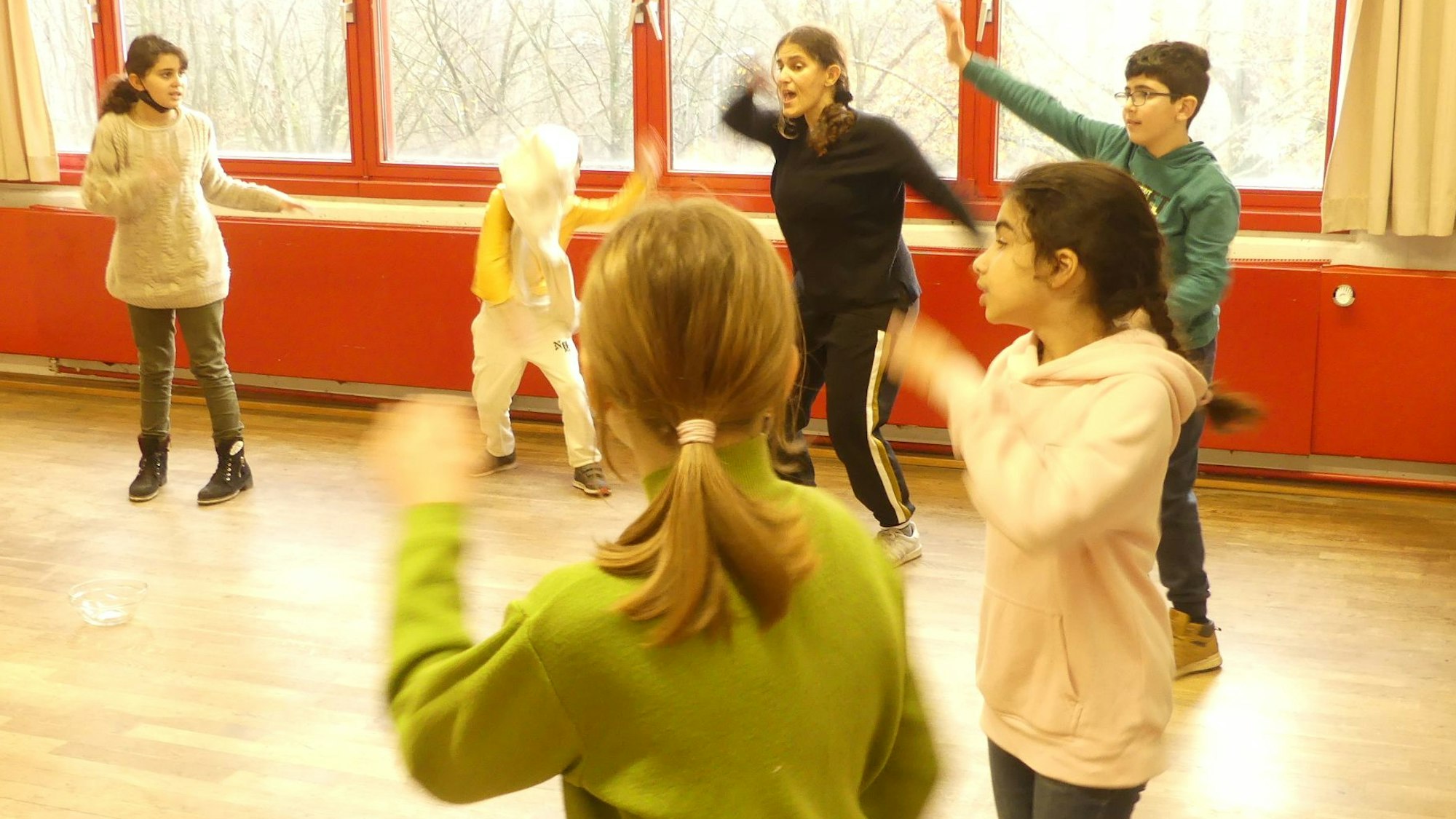 Schulkinder bewegen sich wild im Klassenraum.