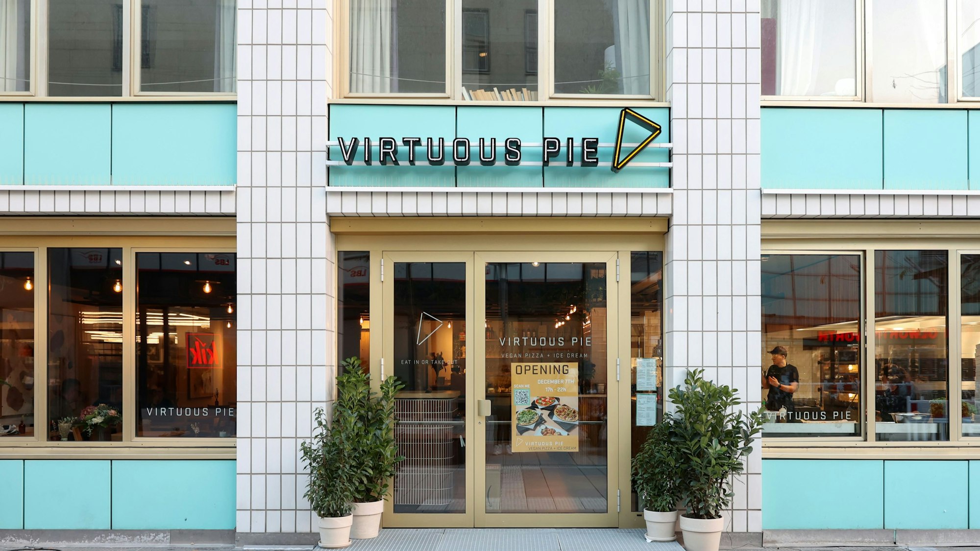 Ausschnitt der türkis-weiß-gekachelten 4711-Hauses mit dem Eingang zum Restaurant Virtuous Pie.