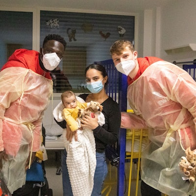 FC-Spieler Kingsley Schindler und Jonas Urbig besuchen Mihriban Burakcin mit dem kleinen Ali Merdan in einem Zimmer der Kinderklinik am Krankenhaus Porz.