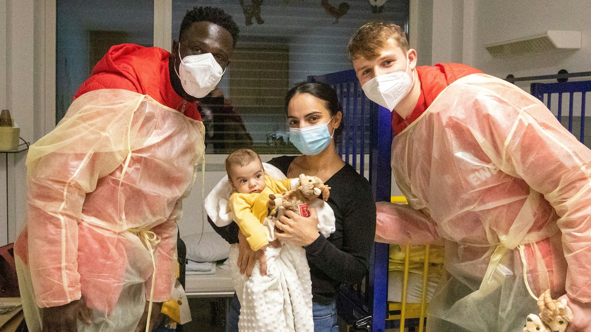 FC-Spieler Kingsley Schindler und Jonas Urbig besuchen Mihriban Burakcin mit dem kleinen Ali Merdan in einem Zimmer der Kinderklinik am Krankenhaus Porz.