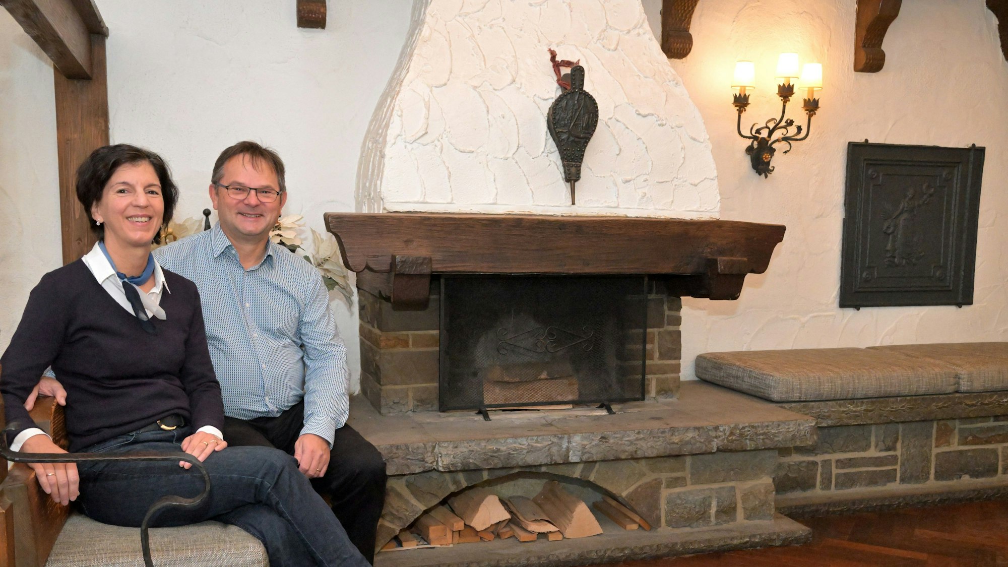 Brigitte und Bernd Klein sitzen am Kamin ihres Hotels.