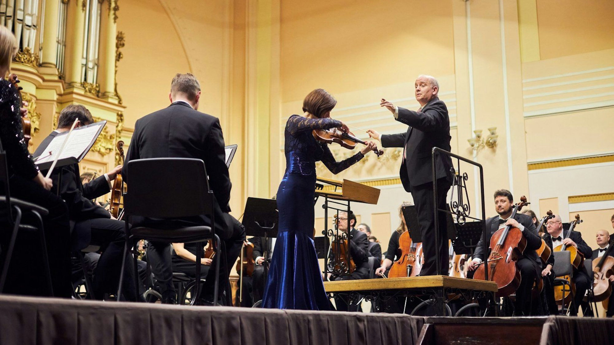 Die Philharmonie spielt auf einer Bühne.