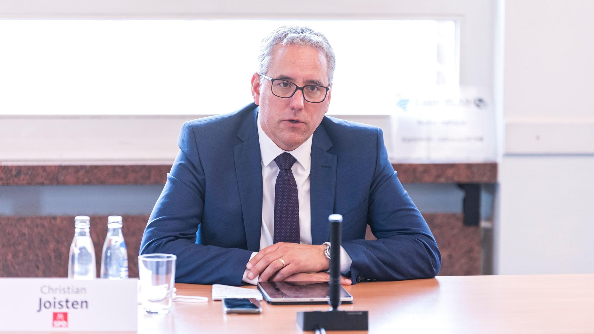 Das Bild zeigt SPD-Fraktionschef Christian Joisten hinter einem Tisch sitzend.
