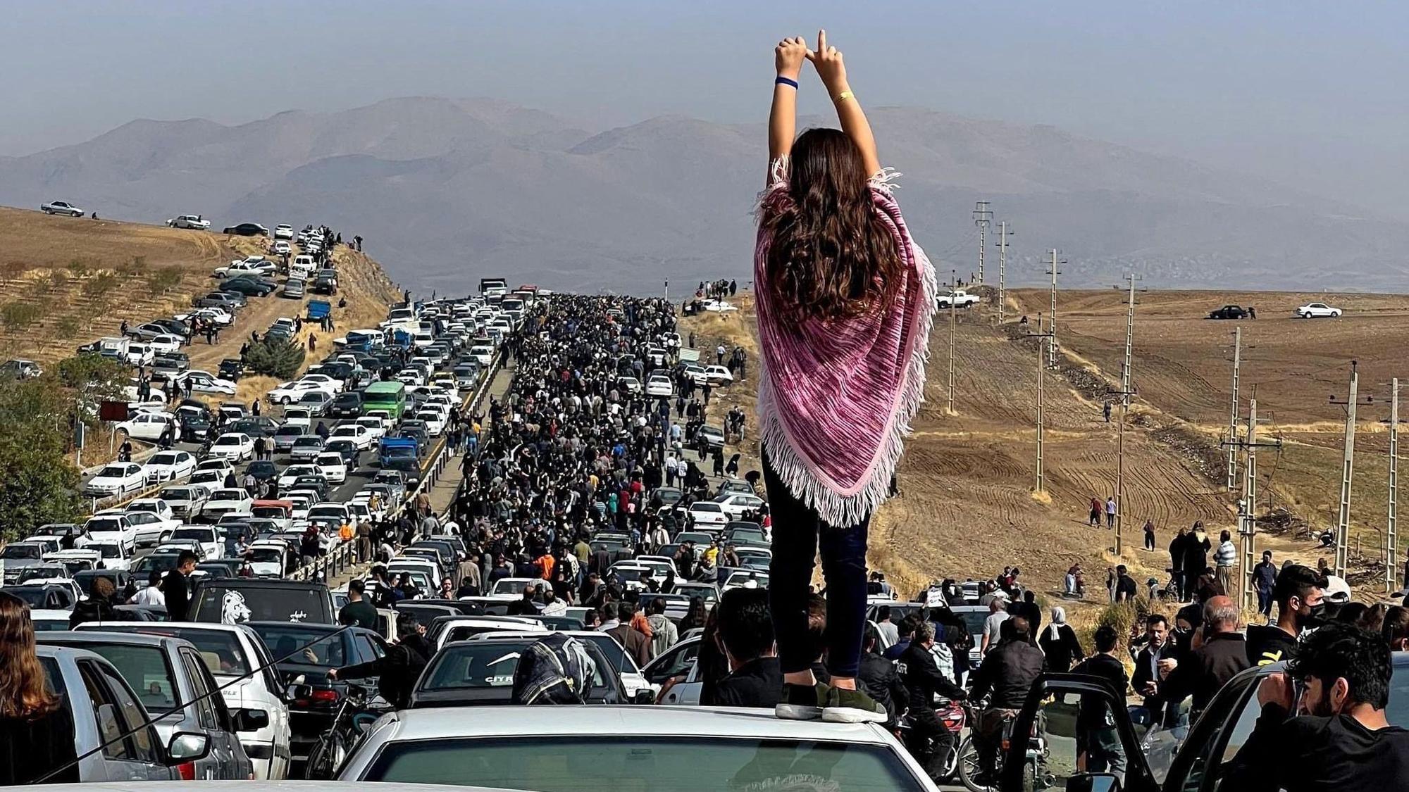 Eine Demonstrantin steht in der iranischen Stadt Saqez auf einem Auto.
