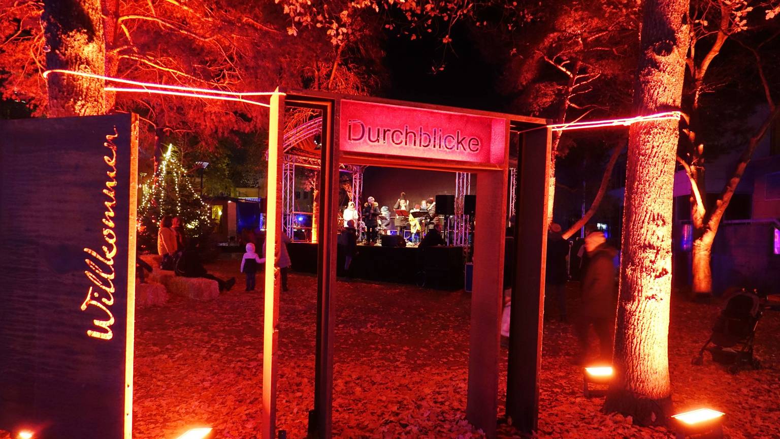 Ein Willkommen in Flammenschrift begrüßt die Besucher im Klosterpark. Ein rotes Tor ermöglicht den Durchblick auf die Eventbühne.