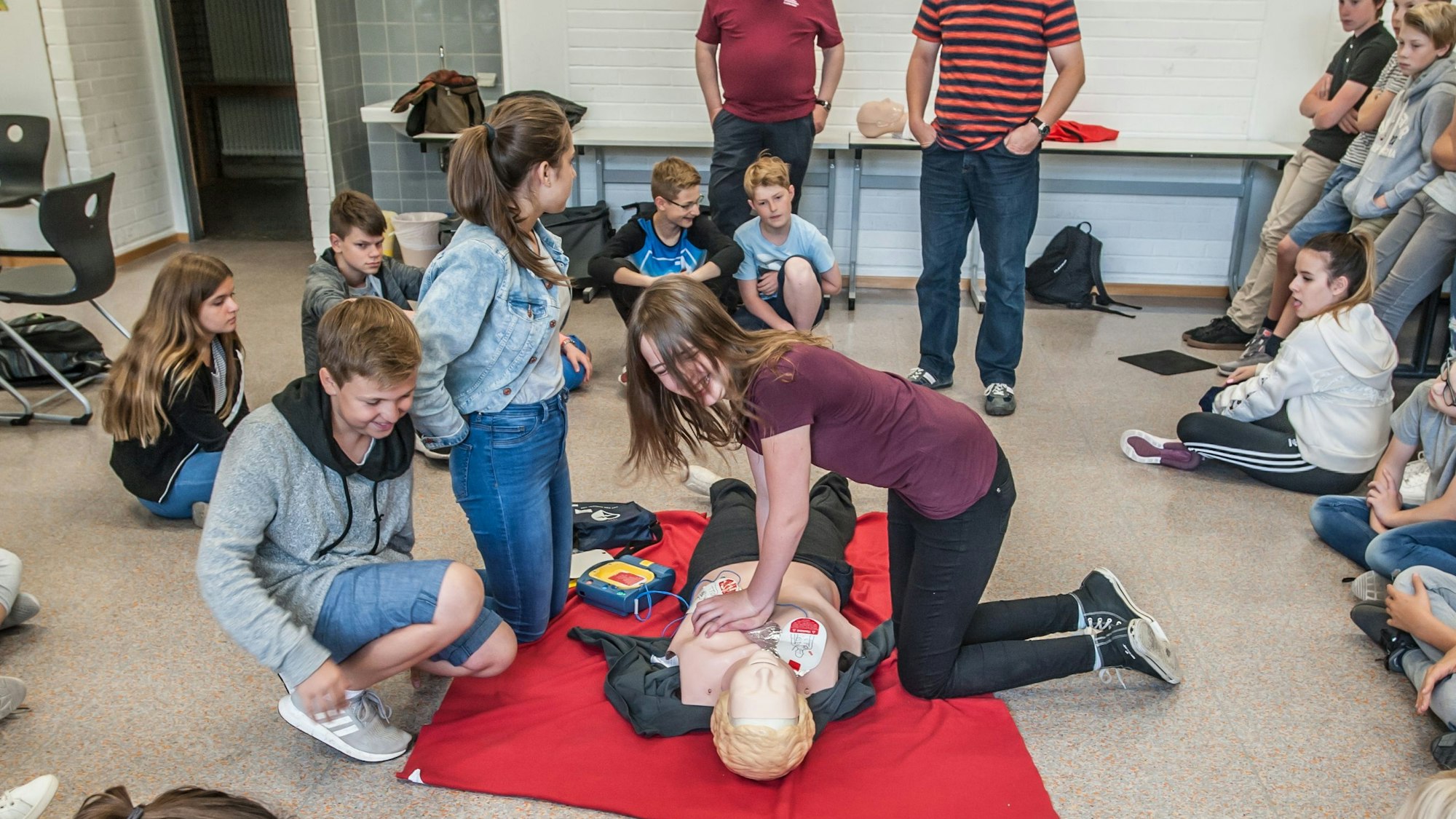 In der Marienschule üben Mädchen und Jungen an einem Dummy Herzmassage und den Einsatz eines Defibrillators.