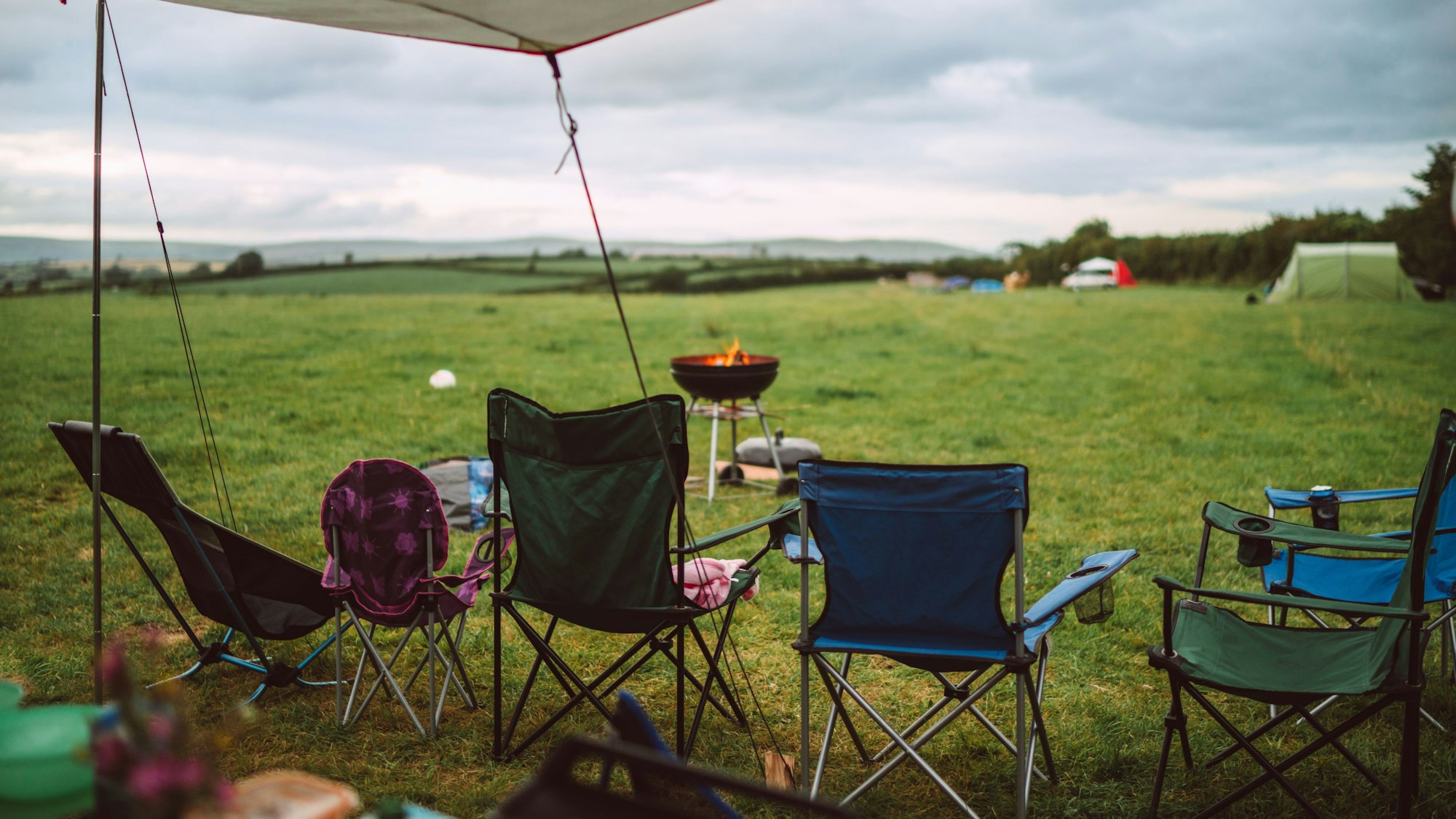 Campingstühle stehen auf einer Wiese.