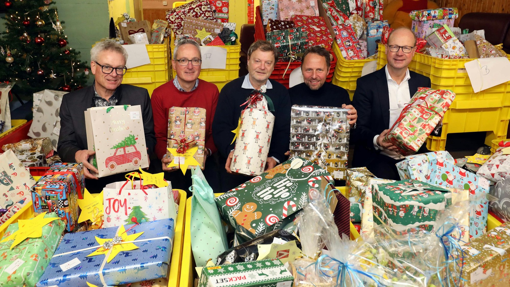 Die Verantwortlichen der Weihnachts-Geschenkeaktion inmitten von Hunderten Geschenken.