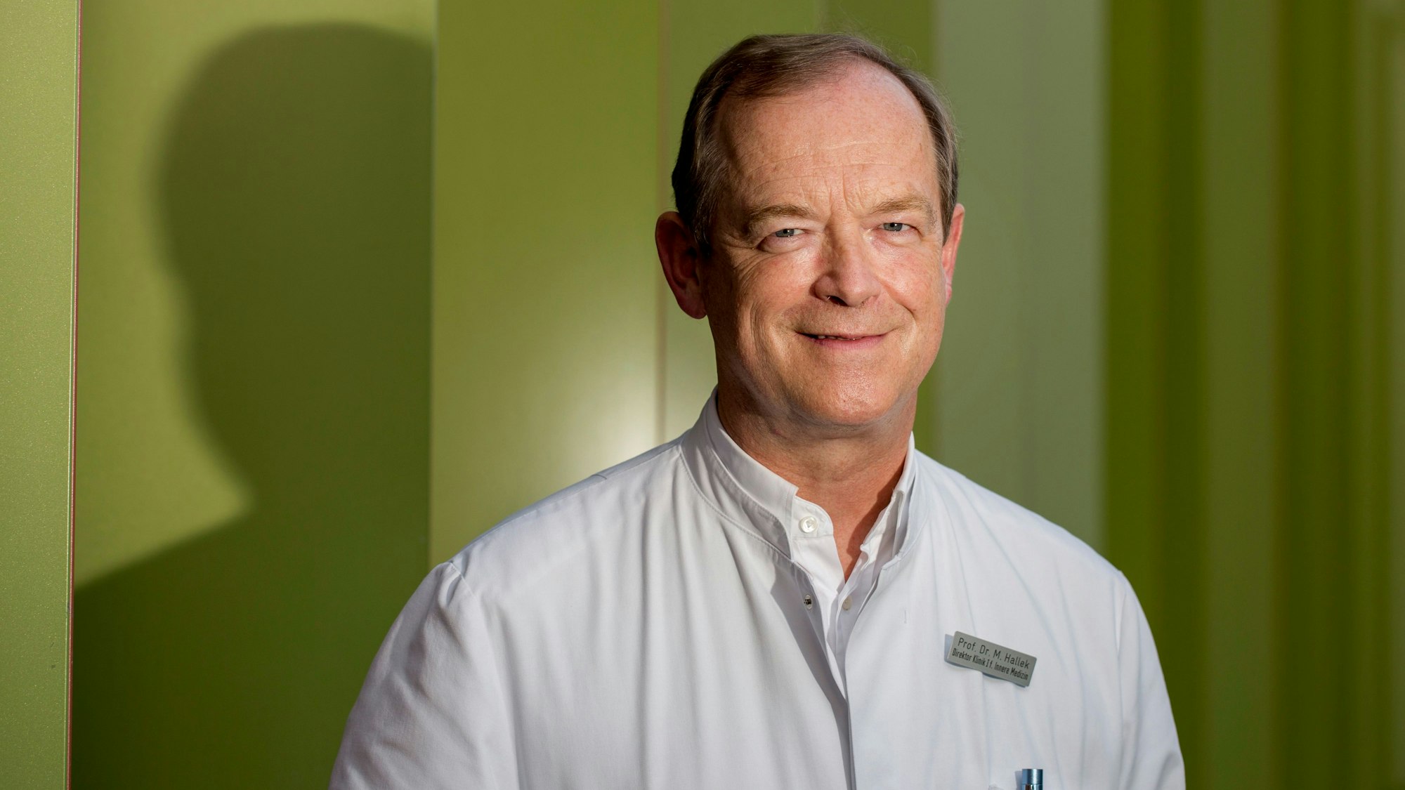 Michael Hallek steht vor der Kölner Uniklinik